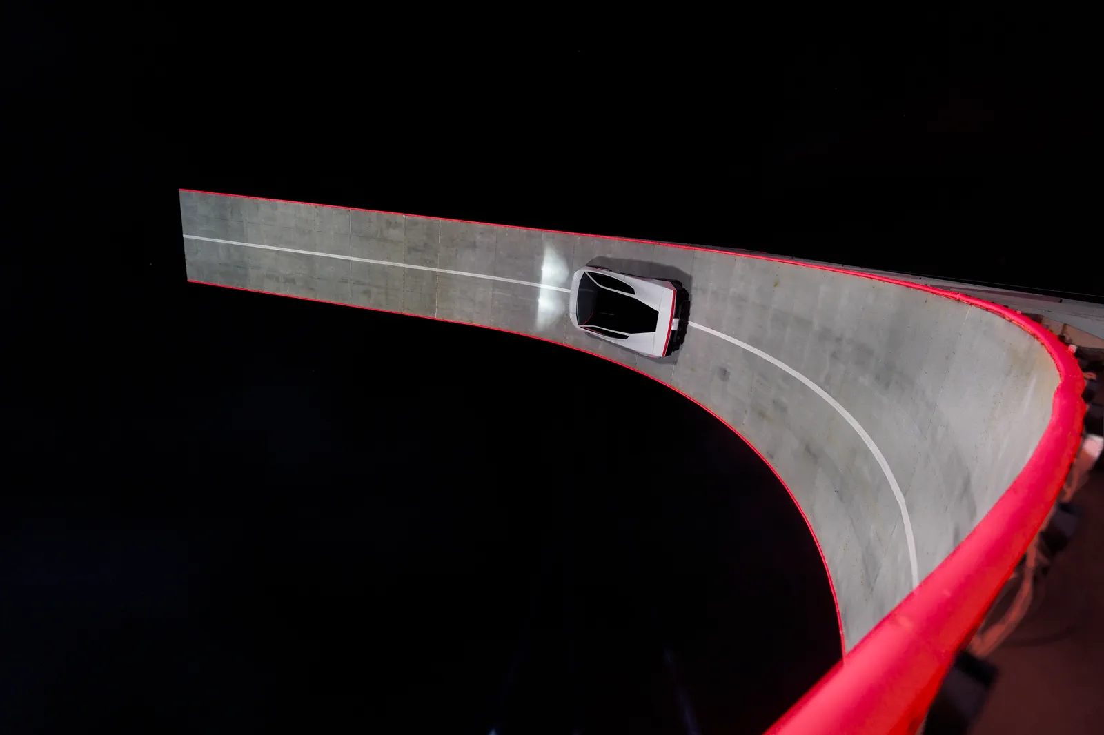 Roadster seen from above, driving the steep banked wall.