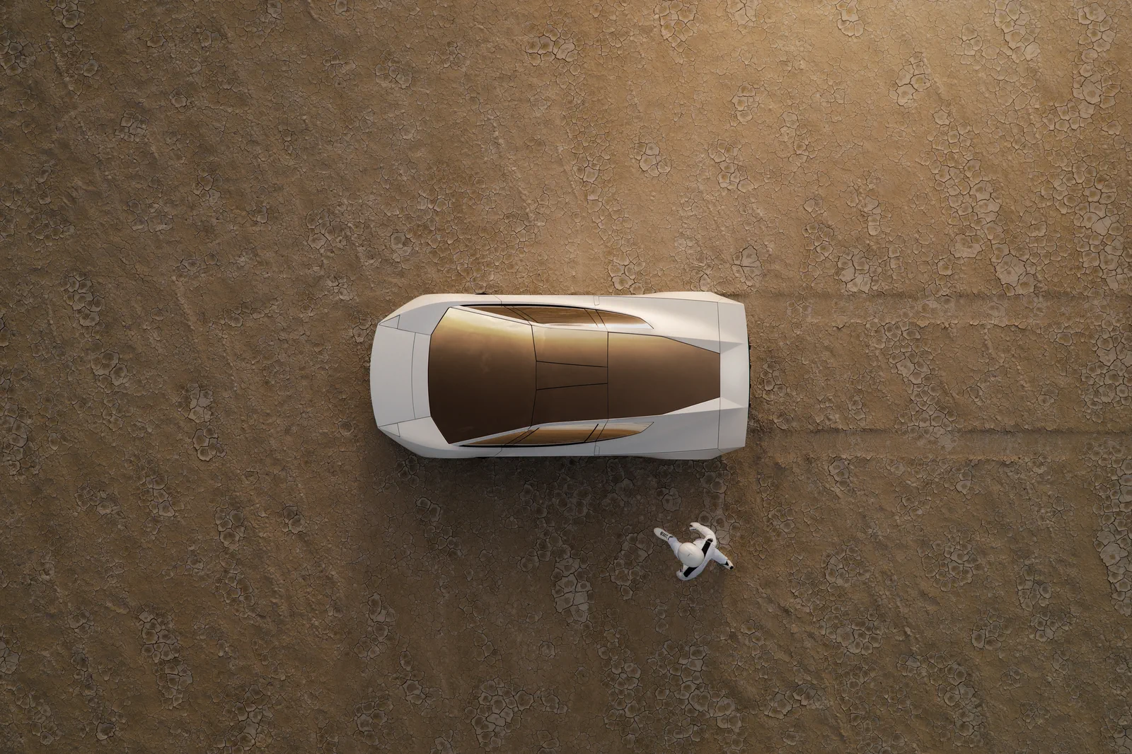 Roadster from directly above on a desert floor, its gold-tinted canopy beside an astronaut.