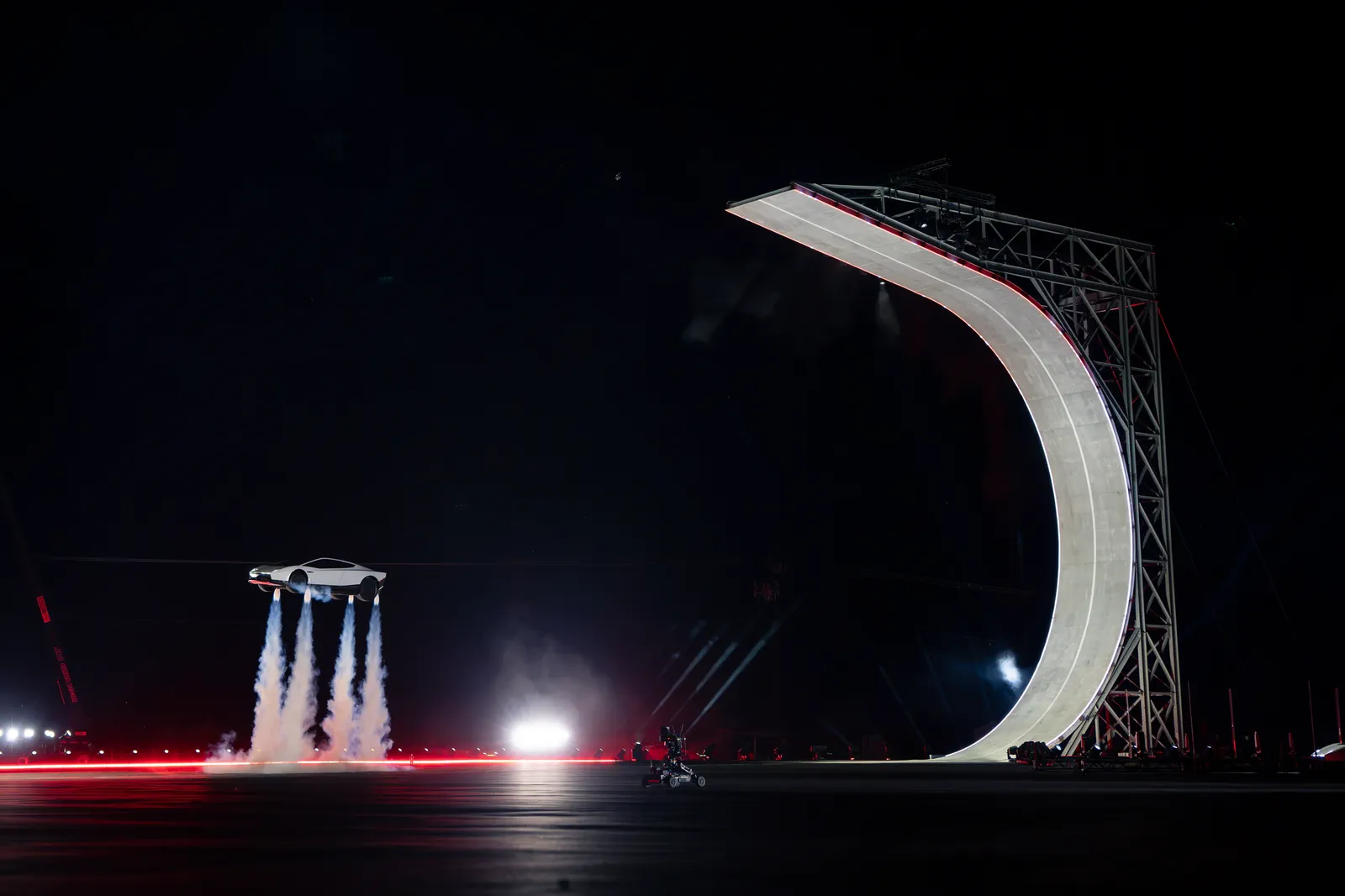 The new Roadster hovering on four cold-gas thruster plumes beside the curved wall.