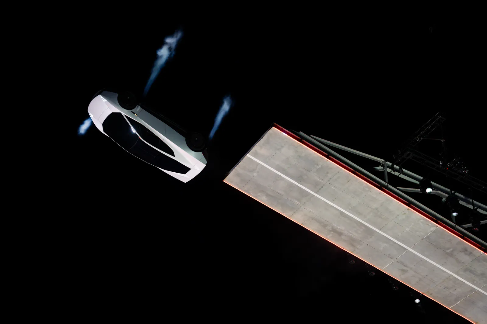 Roadster tipping off the end of the wall, gas jets fanning out.